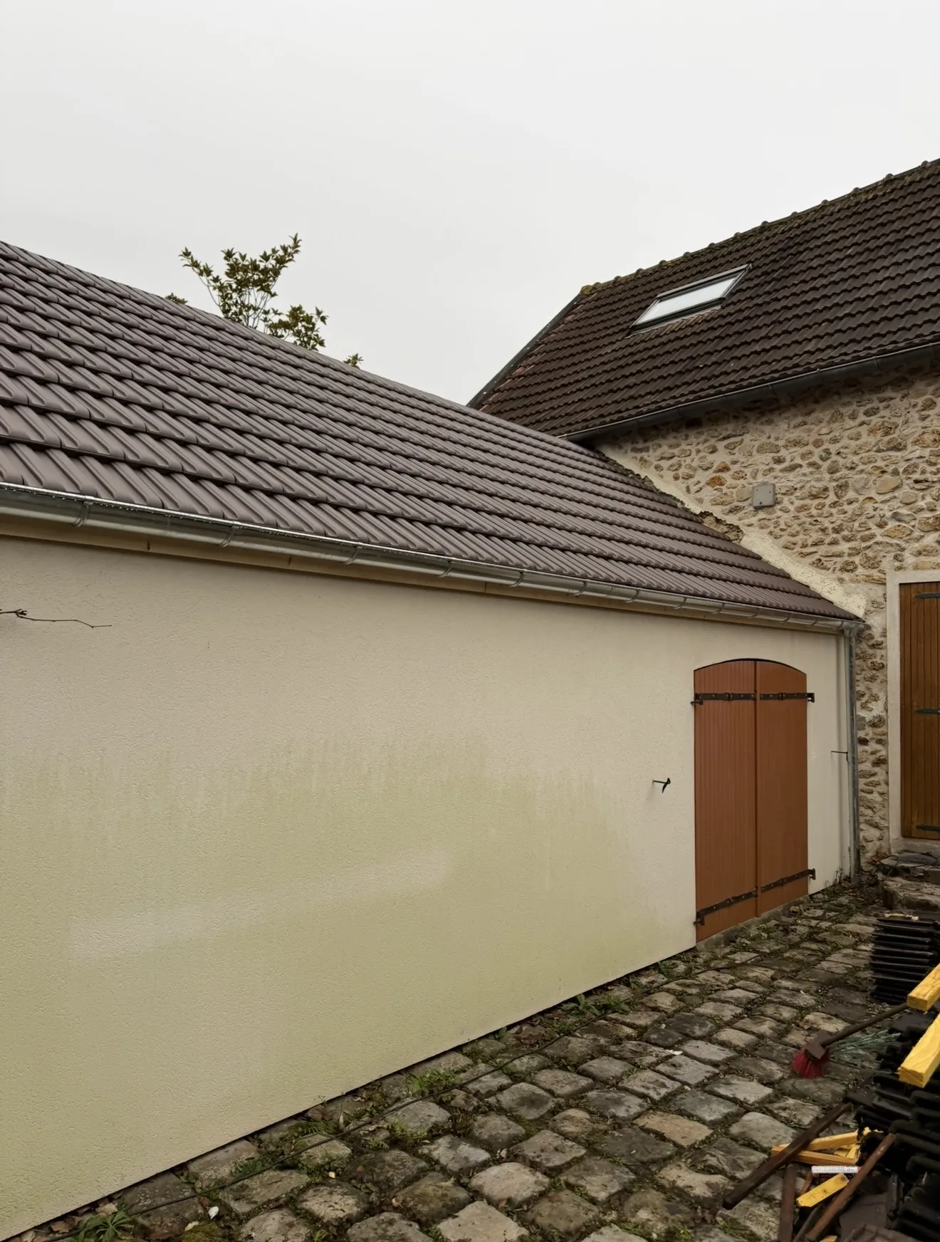 Couverture d’annexe terminée — Tuiles mécaniques posées sur une annexe de cour. Chantier en Île-de-France.