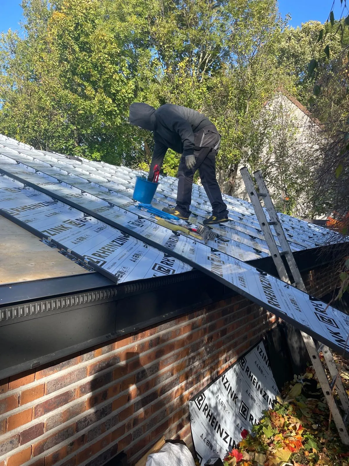 Artisan façonnant le zinc sur une toiture